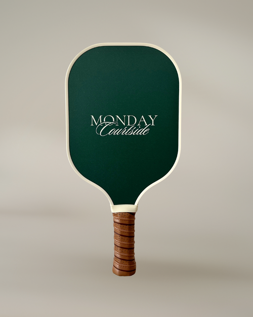 Green pickleball paddle with wooden handle on a beige background