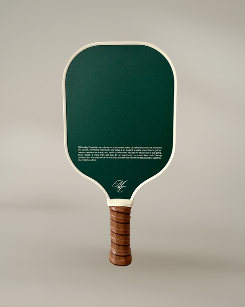 Pickleball paddle with green face and wooden handle on a light gray background